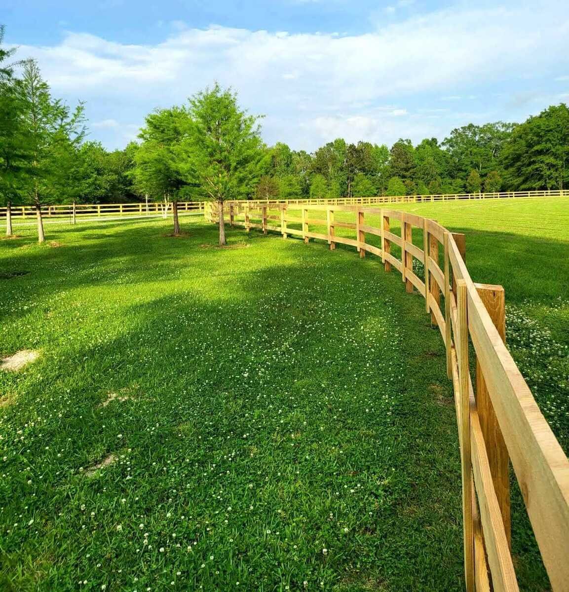 Board fence following a curve across an open pasture